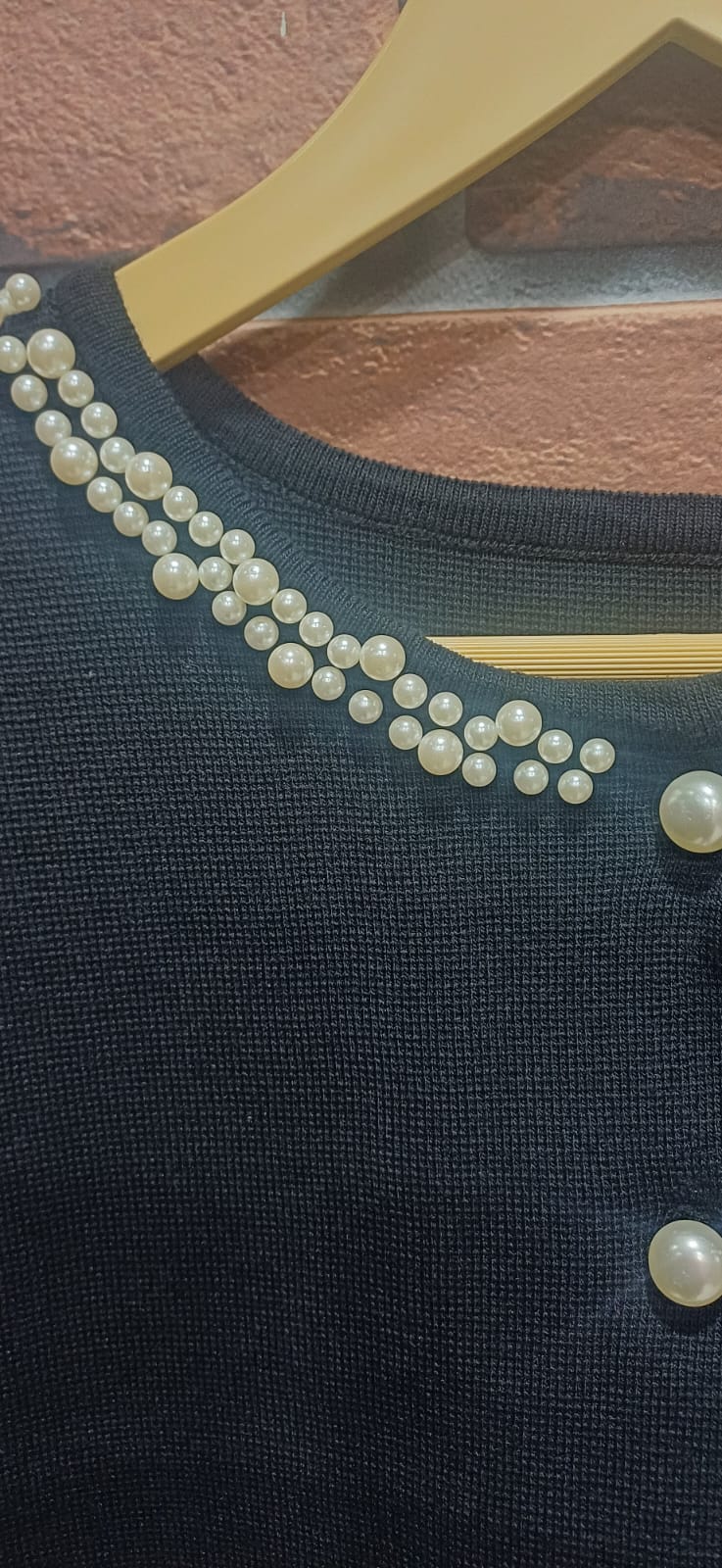 black ribbed knit dress paired with a pearl-detailed shrug