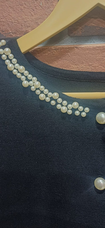 black ribbed knit dress paired with a pearl-detailed shrug