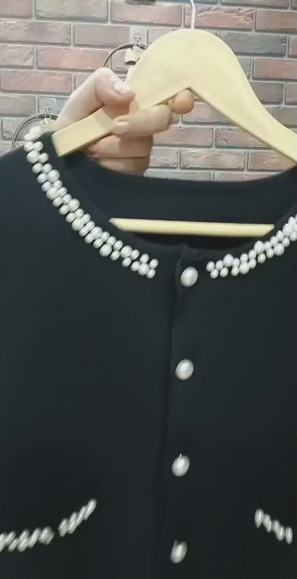 black ribbed knit dress paired with a pearl-detailed shrug